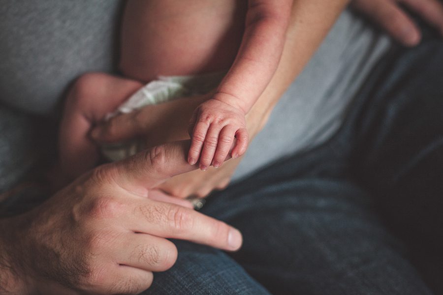 newborn baby holding daddy's finger