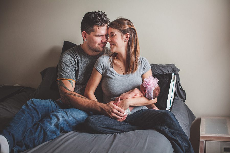 newborn lifestyle shoot of parents on bed