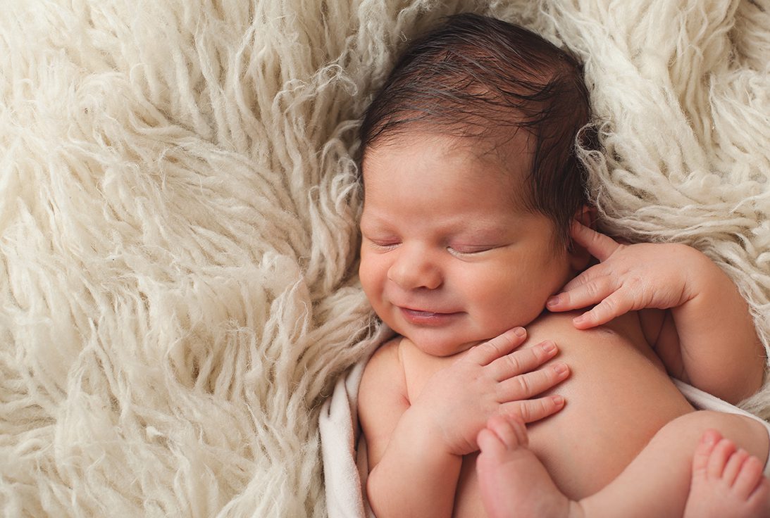newborn boy smiling in flokati
