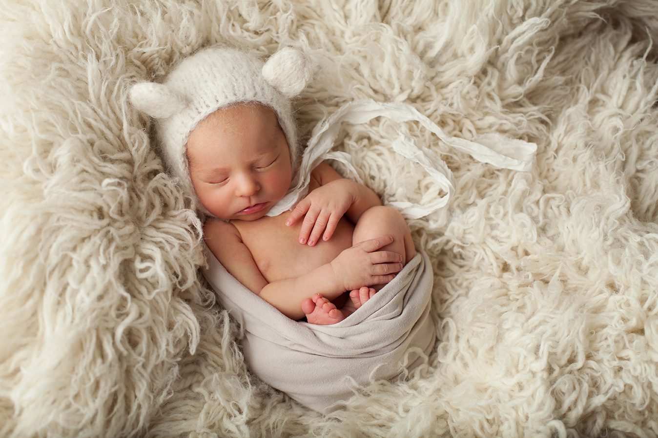 newborn girl with alpaca cream teddy bear hat