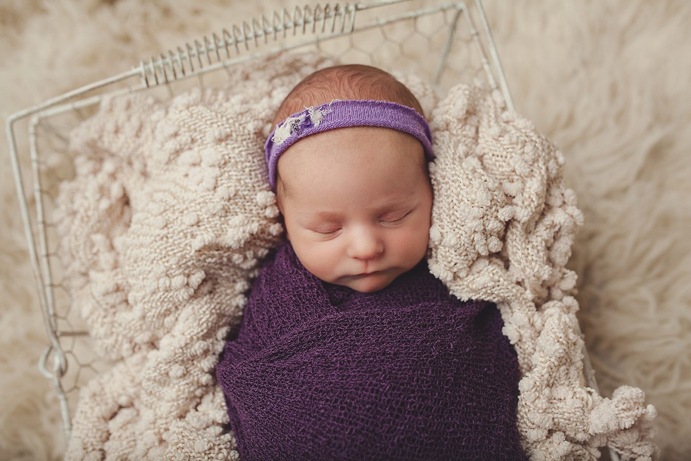 newborn girl wrapped in purple