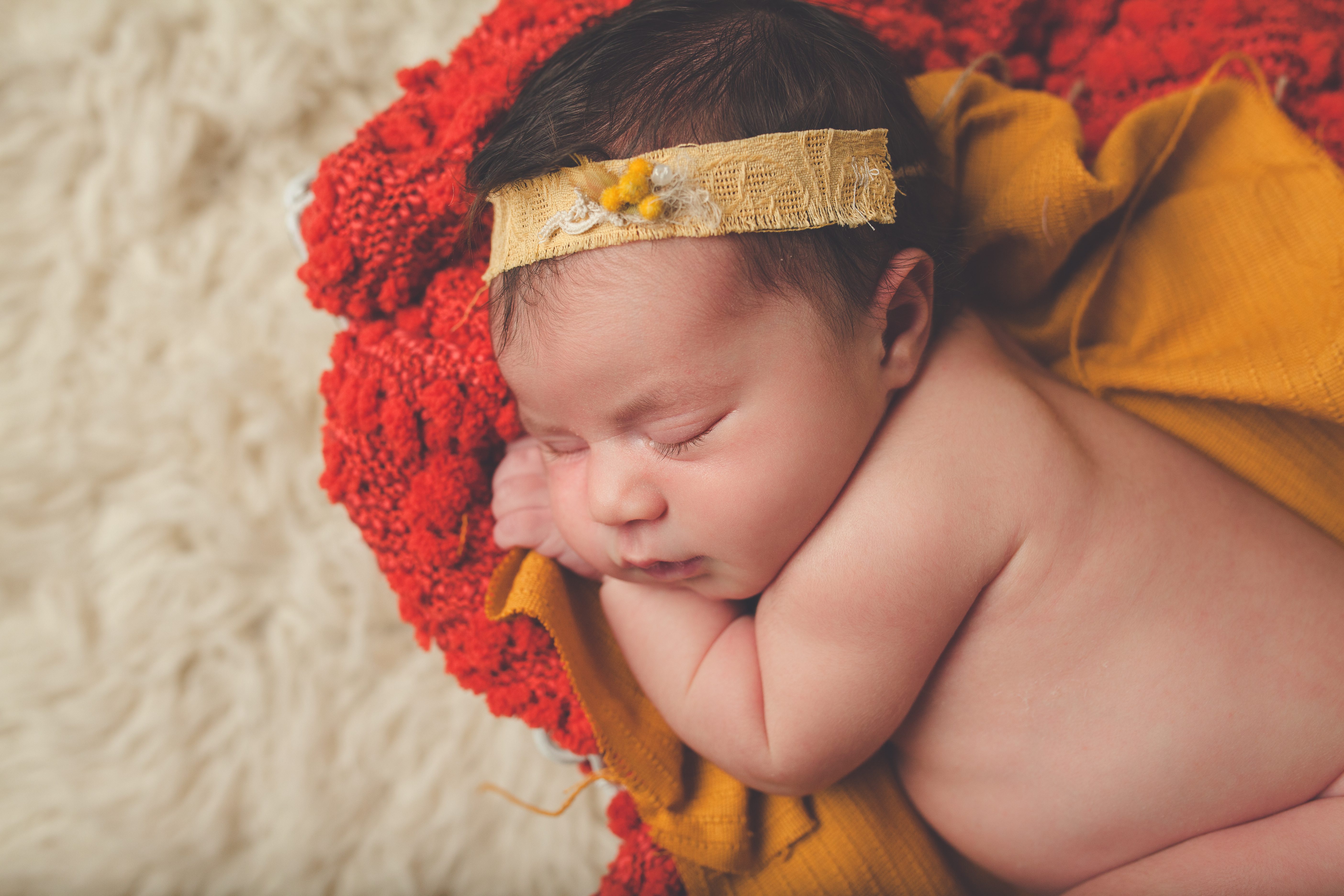 newborn posed with mustard yellow headband