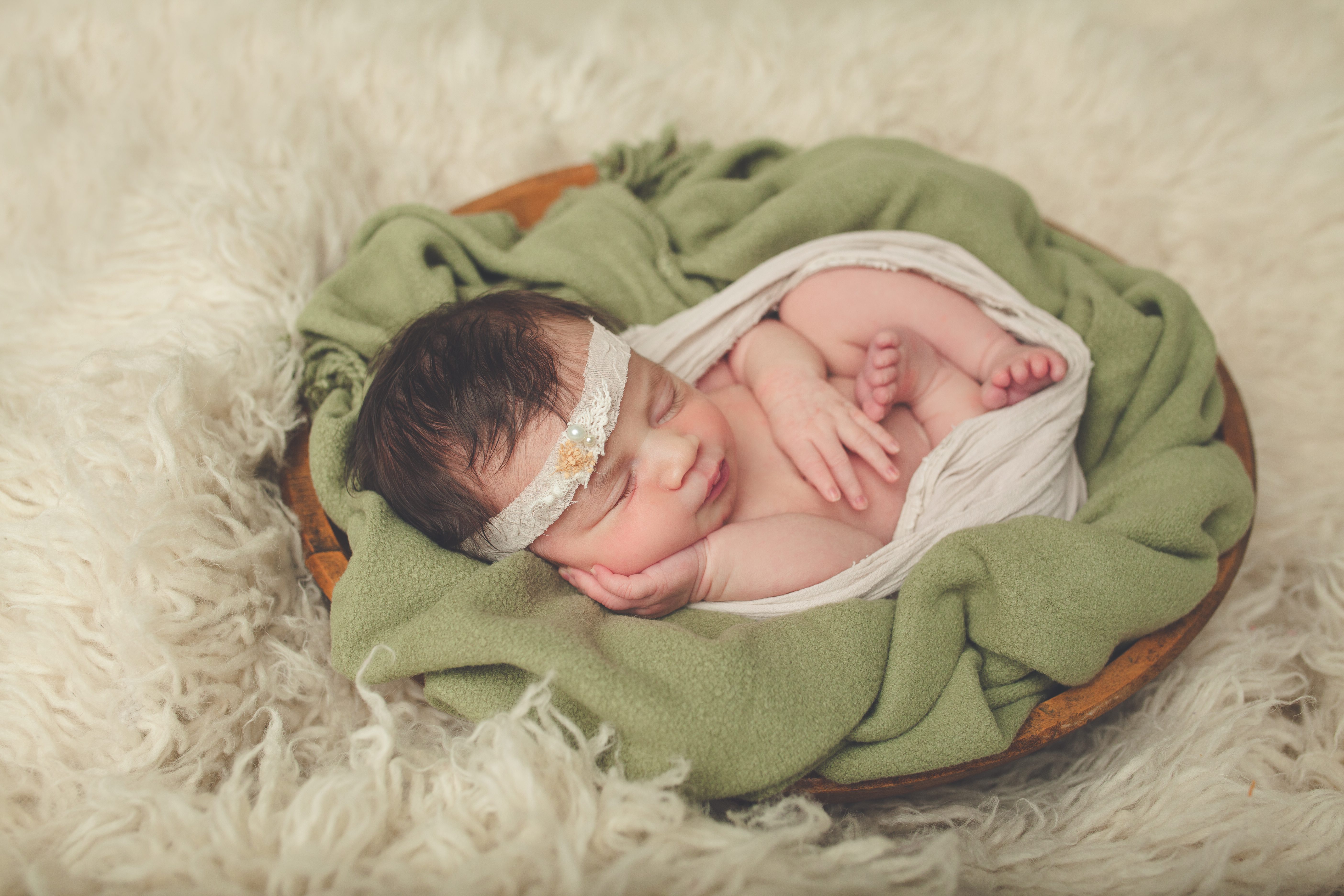 newborn posed in bucket wrapped tight
