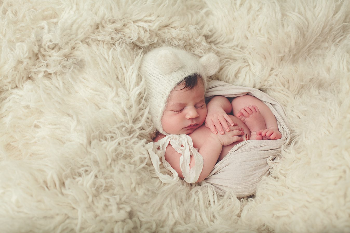 posed newborn photography wrapped in flokati