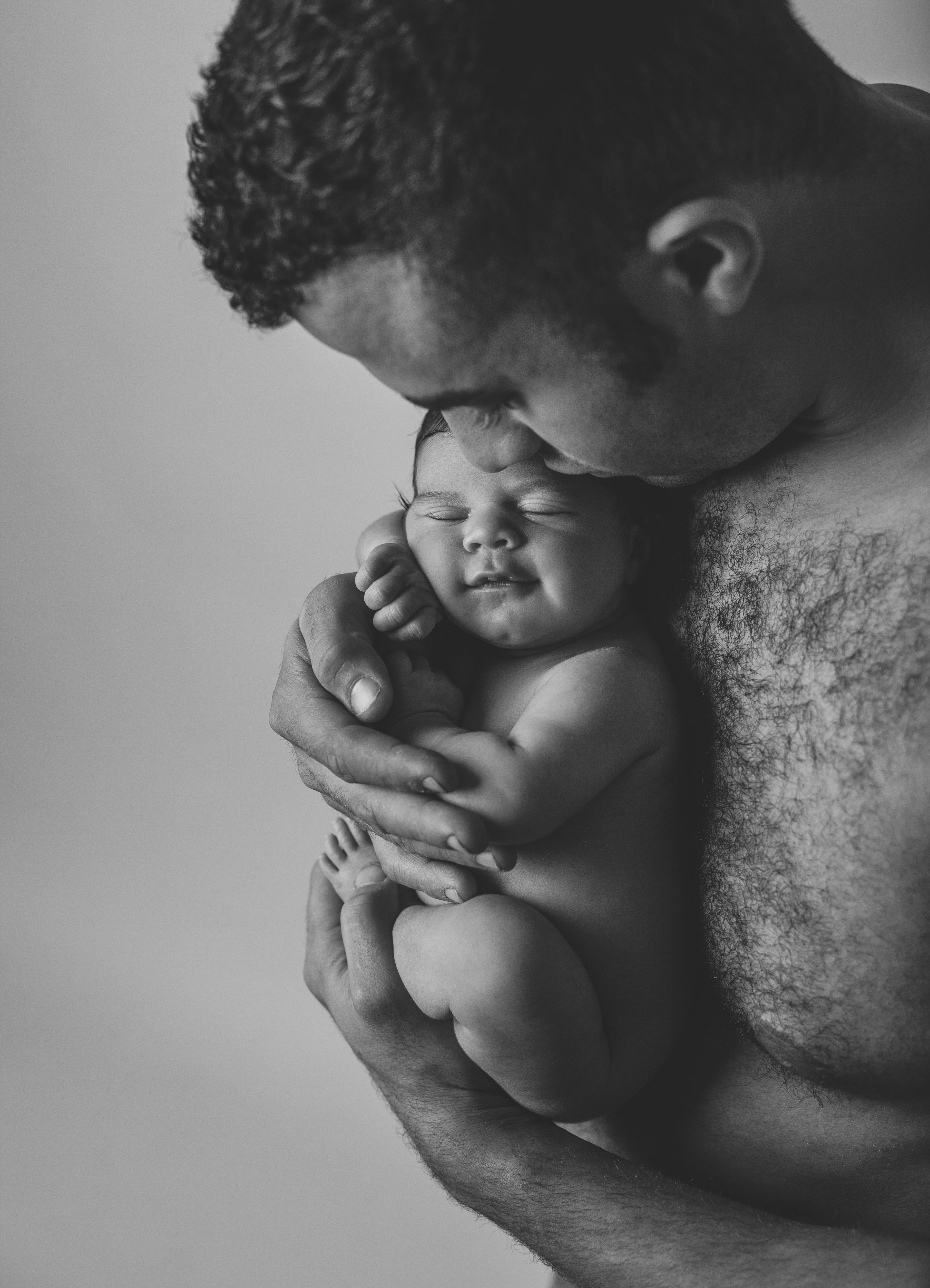 newborn girl smiling in daddy's arms