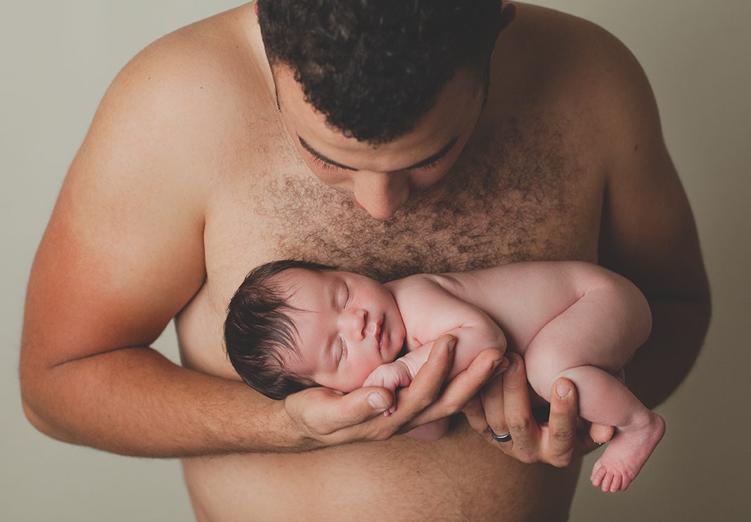 daddy holding baby posed newborn photography