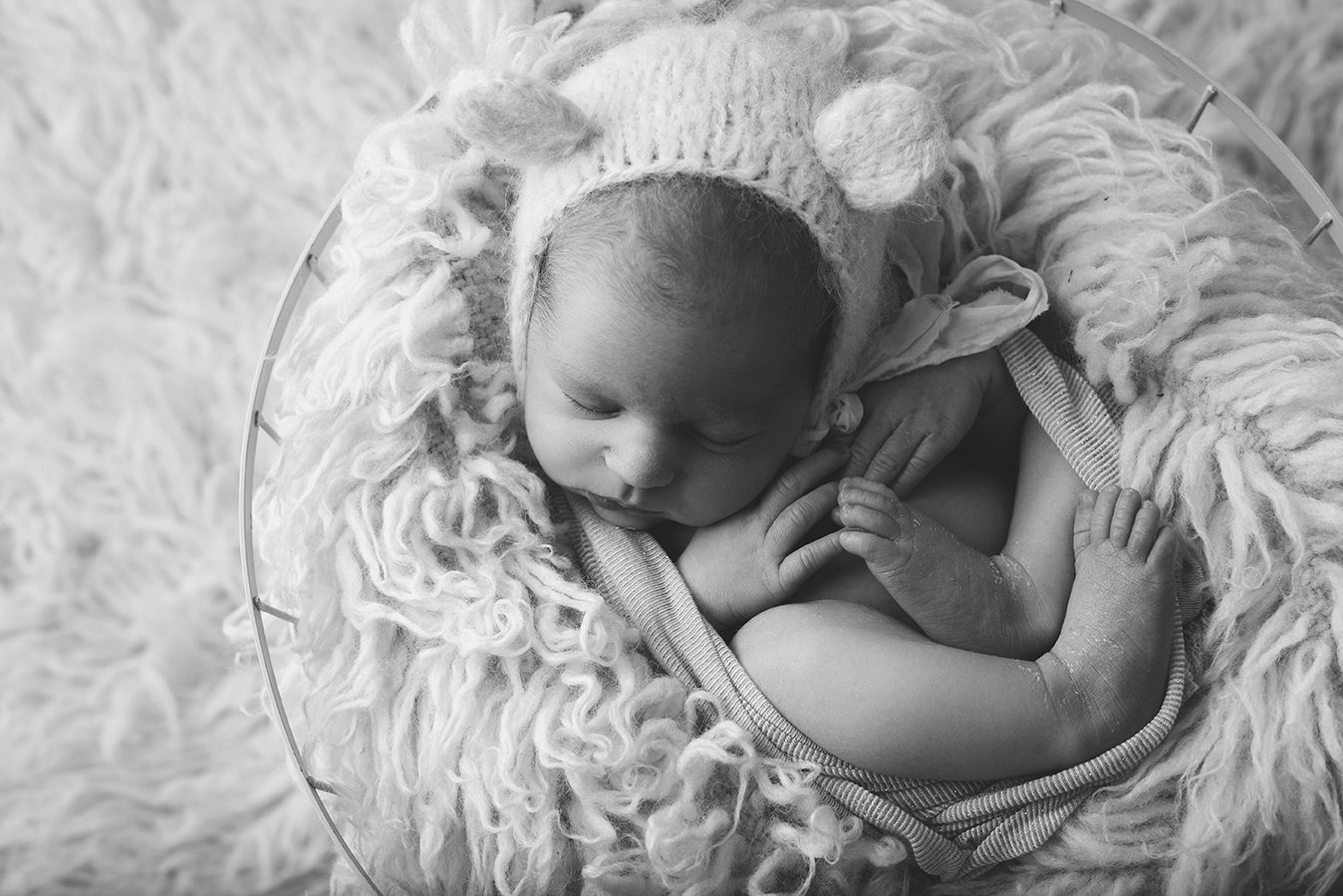 black and white image of newborn in basket