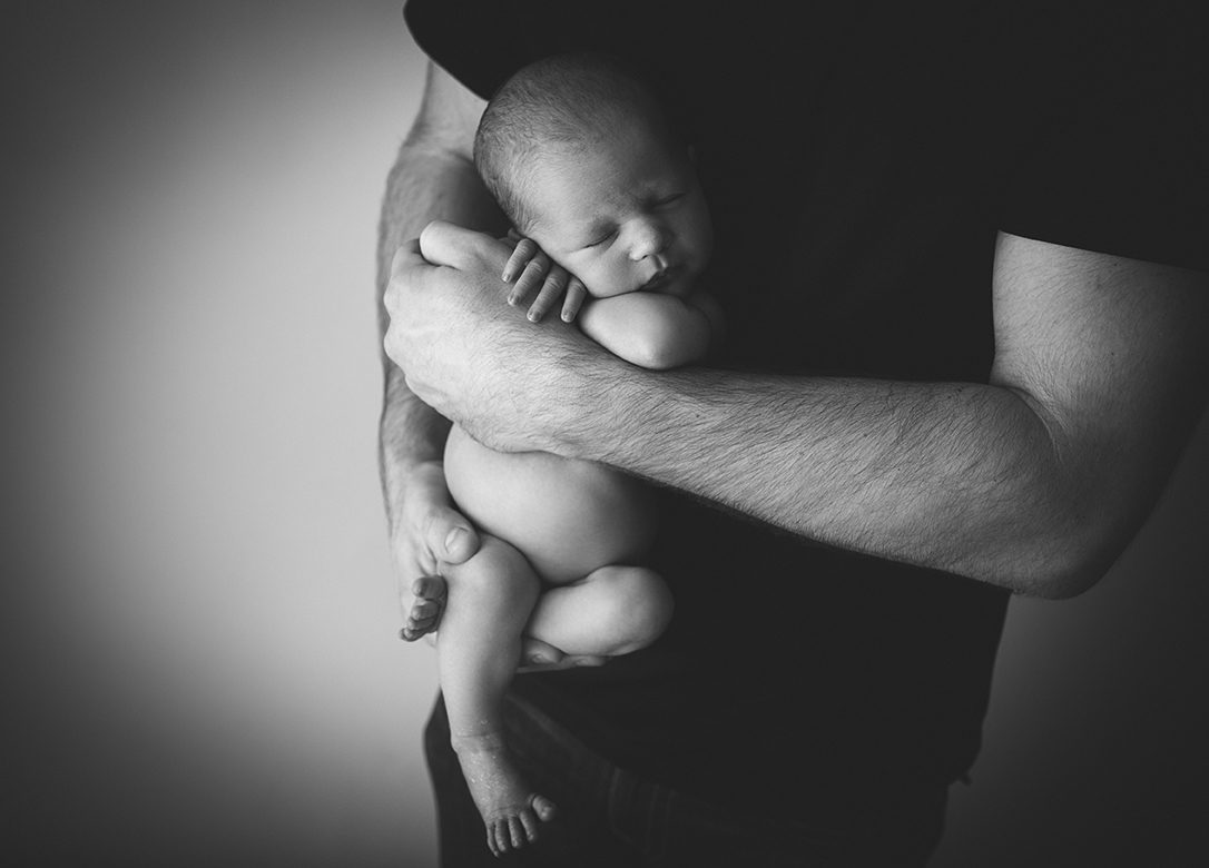 black and white of edmonton newborn posed in daddy arms