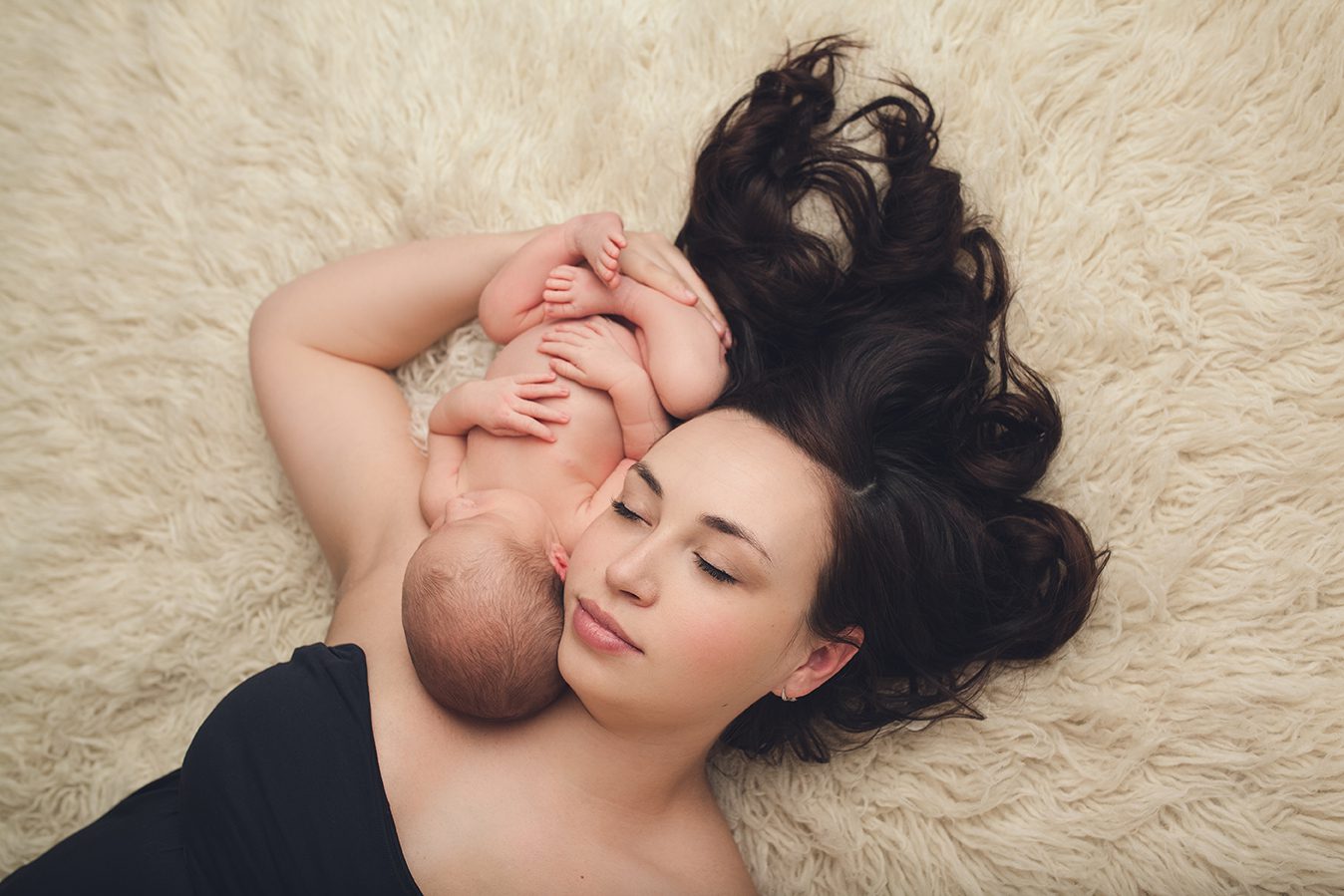 edmonton newborn photographer of mother laying on flokati with baby