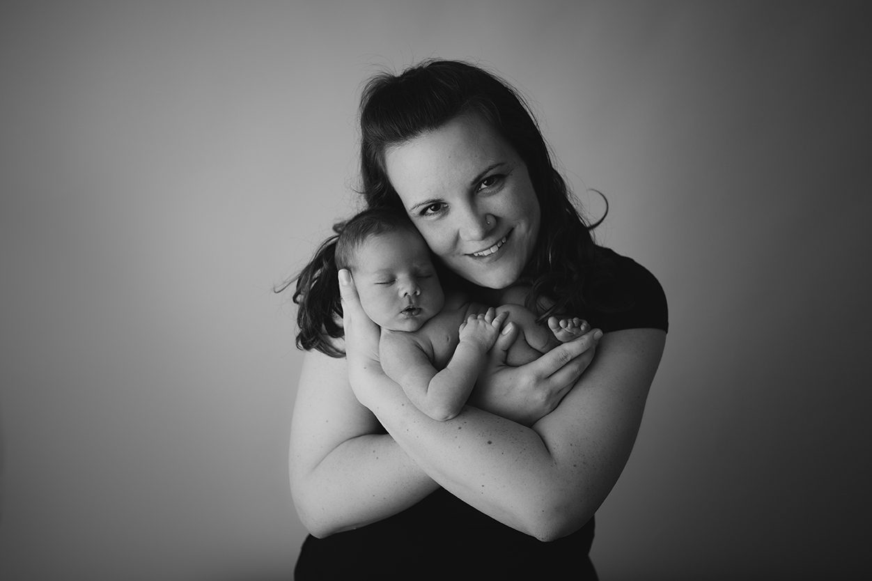 mommy posing with newborn in arms