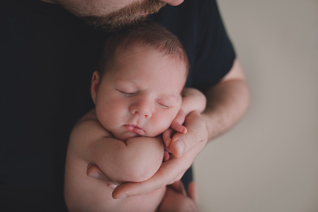 newborn posed in dads arms