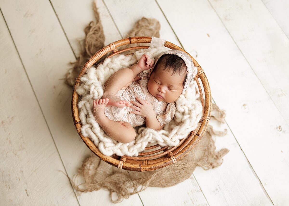 newborn baby girl in a papasan chair
